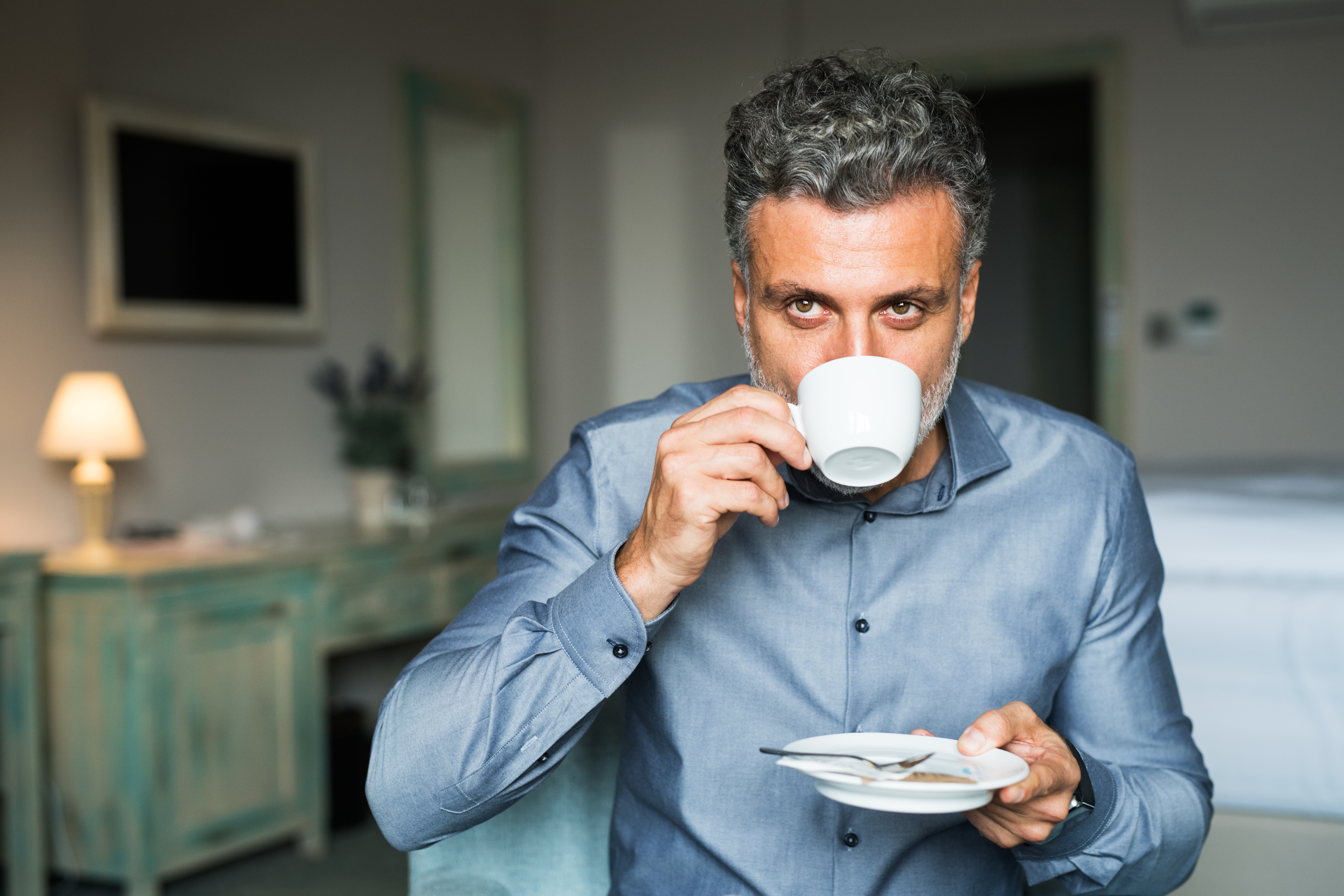 mature-businessman-drinking-coffee-in-a-hotel-room-2023-11-27-04-49-31-utc_01929fdb610c7811be821564cb734714